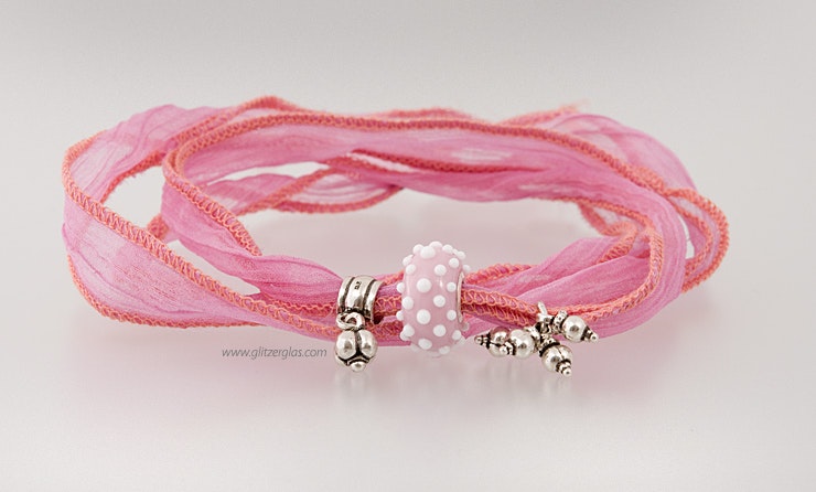 Rosa Glasperle in Pandora- und Trollbeadstyle an rosaroten Seidenband. Mit Echtsilberschmuck 925 bestückt. CHF 58.-