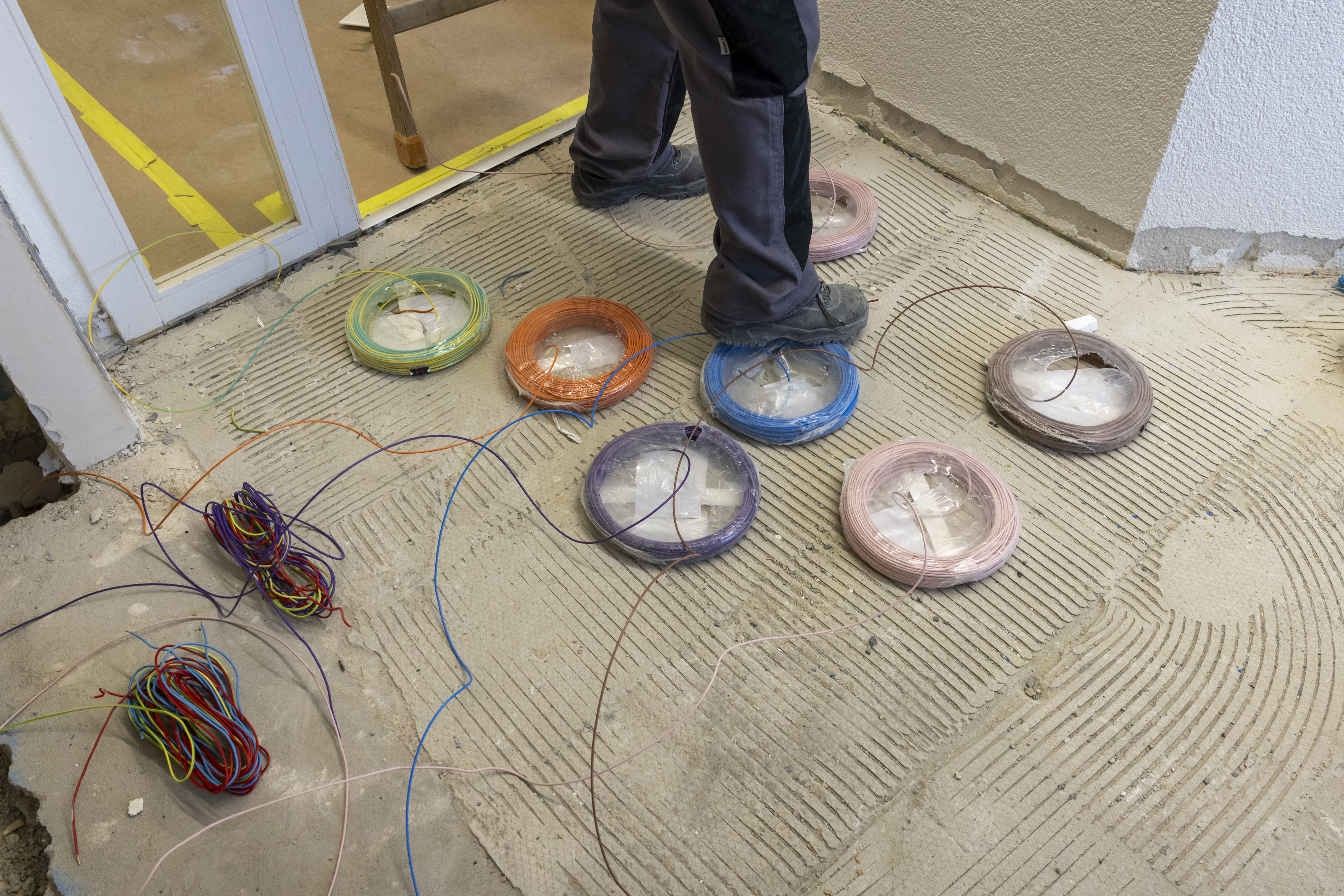 Ein Elektriker verlegt Kabel in einer Wohnung. Ein Elektriker verlegt Kabel in einer Wohnung.
