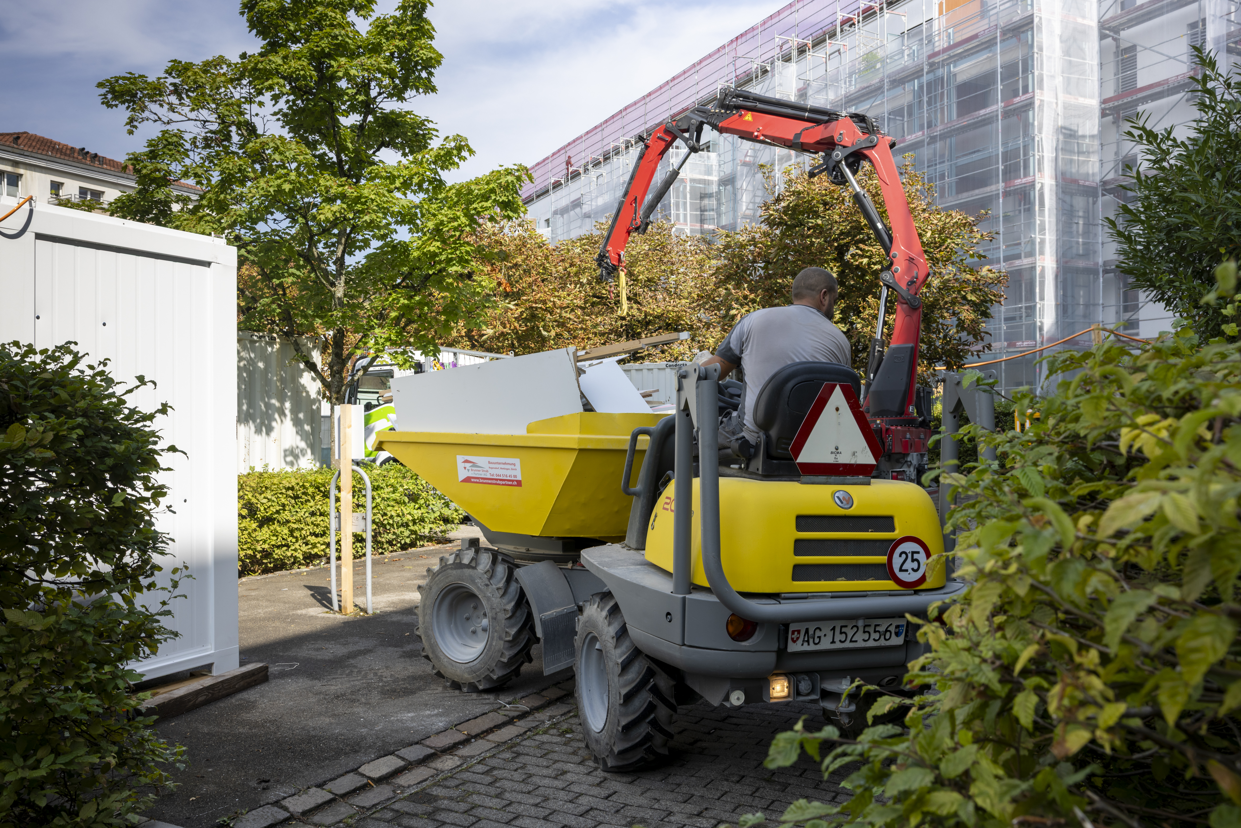 Ein Bauarbeiter transportiert Abbruchmaterial aus der Siedlung. Ein Bauarbeiter transportiert Abbruchmaterial aus der Siedlung.